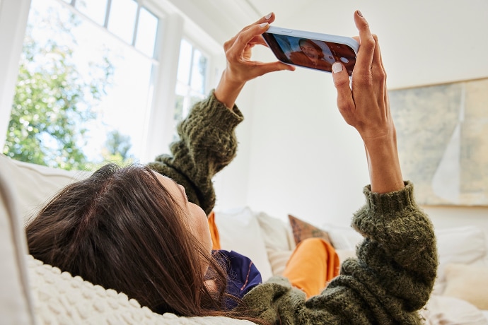 Woman lying down looking at a mobile phone